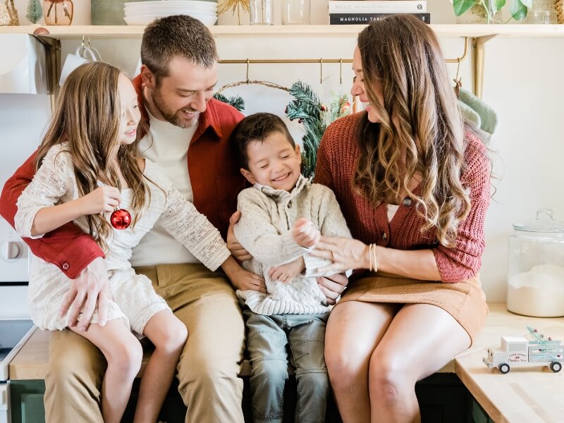 Family enjoying a cozy holiday with minimalist sustainable decor, focusing on quality time over excess.