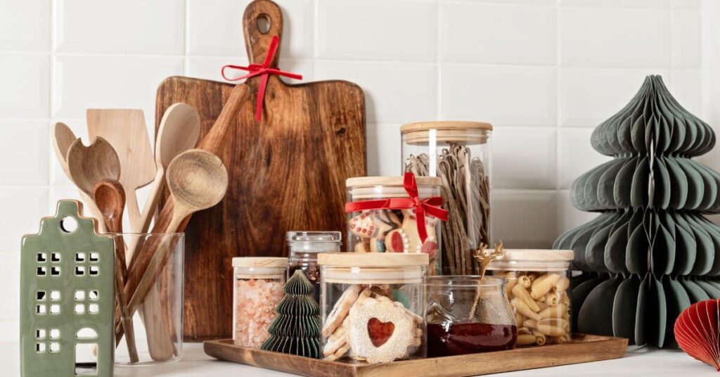 Minimalist holiday table setting with sustainable decor like paper trees, wooden kitchen utensils, and homemade gifts.